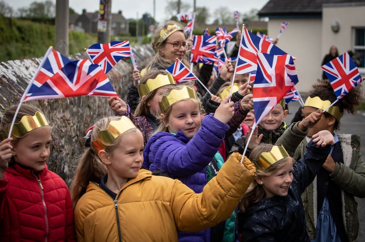 Primary school children from Templeton Community Primary School, Narberth, Pembrokeshire, kick off their Platinum Jubilee celebrations with a colourful parade through the village, waving flags and singing, whilst dressed in their decorated gold crowns and iconic red buses. The children danced a maypole on the village green with red, blue and white ribbons for the onlooking residents, as well as created Platinum Jubilee mosaics which will now remain a permanent fixture in the village.