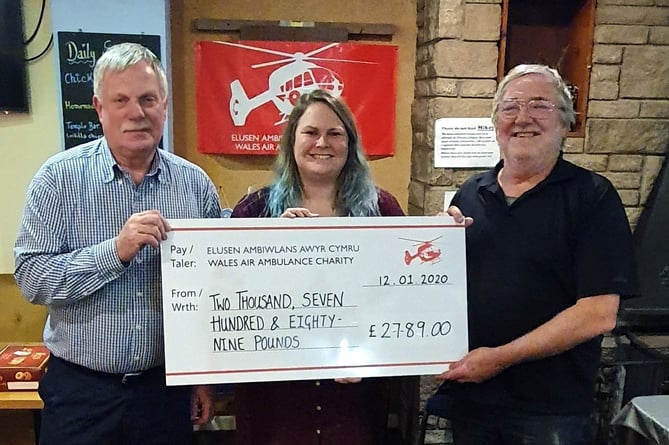 Pictured presenting a cheque for a couple of years’ amount raised to the Wales Air Ambulance charity are Peter Kraus and John O’Connor. Receiving the donation was Katie Macro.