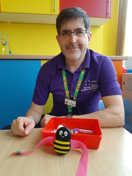 Paul Harries, Health Play Specialist, with the Buzzy Bee tool and items used for blood tests.