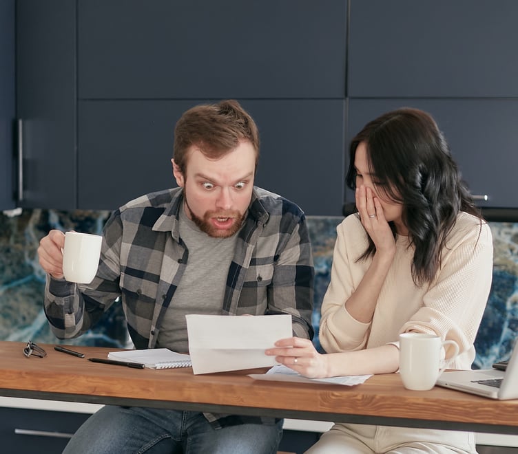 https://www.pexels.com/photo/a-couple-sitting-near-the-wooden-table-while-looking-at-the-document-in-shocked-emotion-6963032/