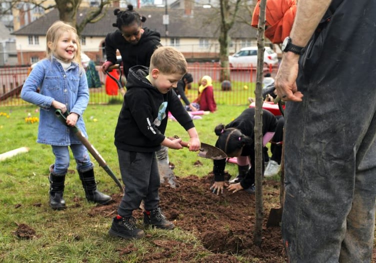 Children bedding in a newly planted apple tree