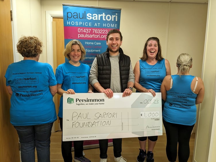 Cheque presentation to the Paul Sartori Foundation, with staff donning the new t-shirts and vests.