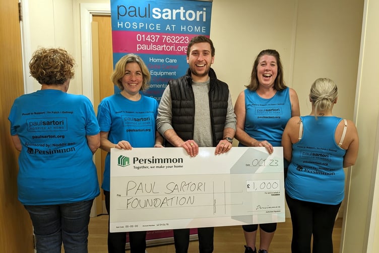 Cheque presentation to the Paul Sartori Foundation, with staff donning the new t-shirts and vests.