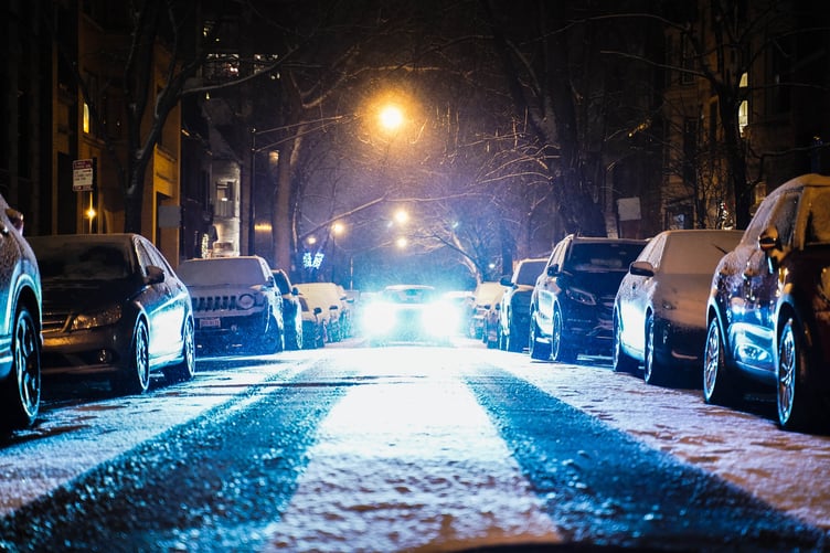 Dazzling headlights on snowy road at night