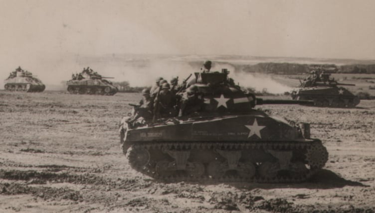 Sherman tanks of the US Sixth Armored Division take part in a training exercise at Castlemartin prior to the Normandy landings. The woods by Brownslade are in the background.