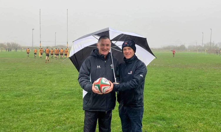 Former chairman of Pembroke RFC Darrell Willington receives the rugby ball from Coxswain Will Chant. (Pic. RNLI/St Davids)