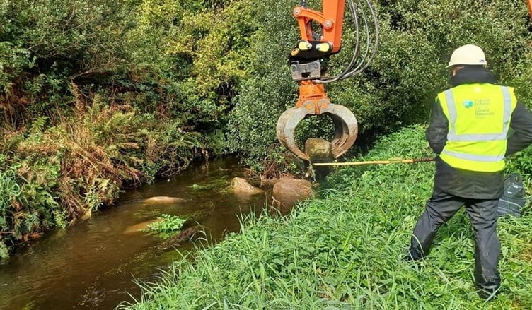 Long reach machinery placing boulders into a stretch of the Western Cleddau River, near Letterston village