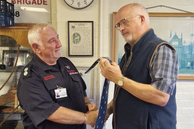 Euros Edwards being presented with a commemorative tie by Deputy Chair of Mid and West Wales Fire and Rescue Authority, Councillor John Davies
