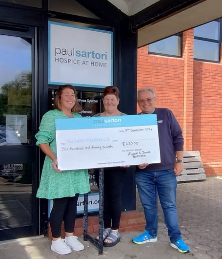 Alyson and Jamie Griffiths have raised £620 for Paul Sartori Hospice at Home at their 25th Wedding Anniversary celebration in Haverfordwest. Pictured with the couple receiving the donation is Grant Development Officer Judith Williams.