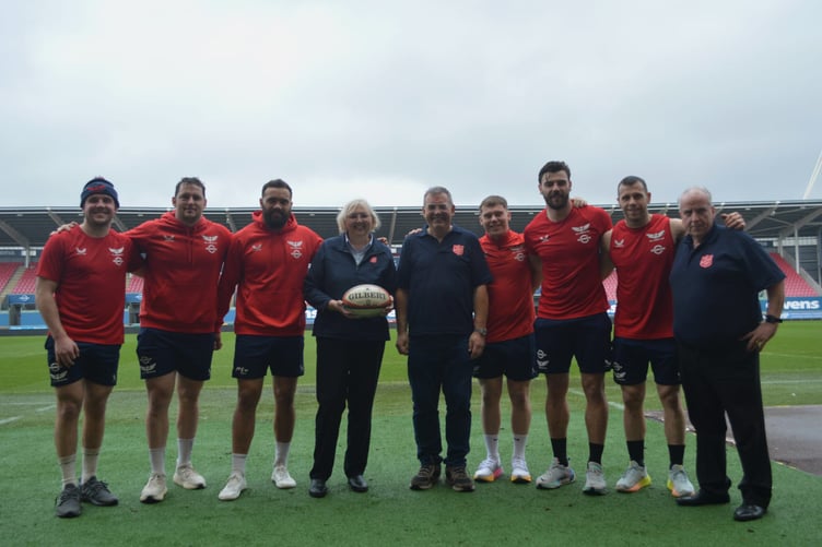 Dave Healey (Scarlets Stadium Manager) with Karen Symonds and Antony Chappell of The Salvation Army in Llanelli and Scarlets Players Johnny Williams (Centre), Ryan Elias (Hooker),  Sam Costelow (Fly Half), Gareth Davies (Scrum Half), Ioan Lloyd (Fly Half/ Fullback) and Josh Macleod (Flanker and Captain)