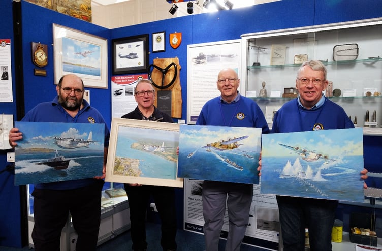 Artist John Wynne Hopkins and three of the Pembroke Dock Heritage Centre Volunteer Team display the original Sunderland paintings. Left to right: Martin Vickery, John Wynne Hopkins, Steve Lyons and Mike Reeve. Photo: Martin Cavaney Photography