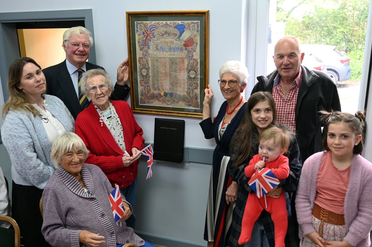 With the rededicated Roll of Honour at Amroth Parish Hall are Lieut Col Charles Carter, India Griffith, Jane Hall, Pam Gibson (seated), Rosemary Tippett Maudsley, William Thwaites, Beatrix Wilson holding her baby brother Rex, and Florence Wilson.