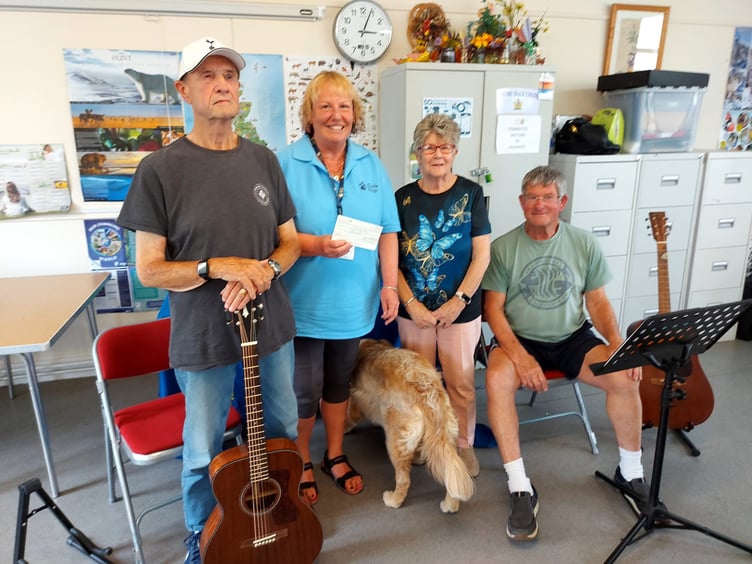 Seen with musicians John and Chas, Sue Canham receives the cheque for Guide Dogs Cymru from Tenby Friendship Club chair Anne Elms