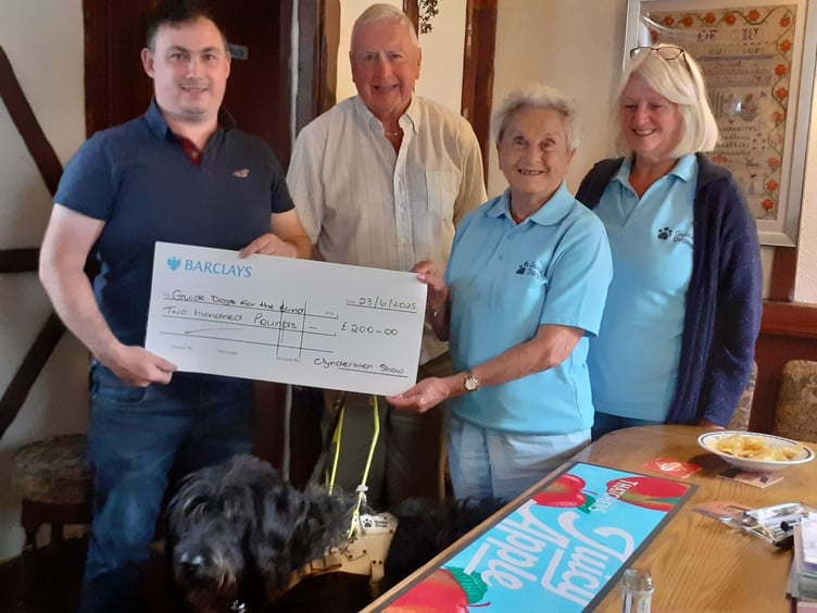 Adge John, guide dog Skip, Eva Rich and Sheila Ravenscroft receiving the donation from Clynderwen YFC Show Committee.