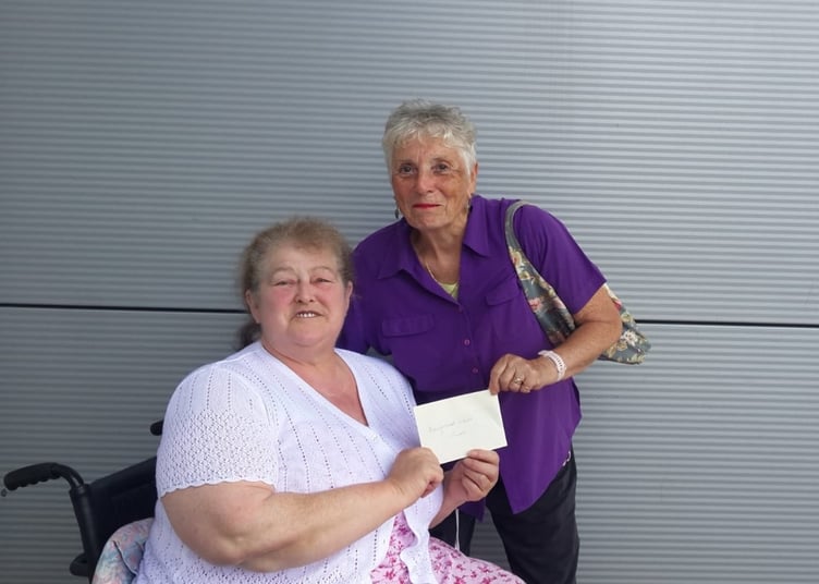 Summerhill WI treasurer Linda Brown handing the raffle proceeds to Rev'd Patrica Rogers of Haverfordwest Street Pastors
