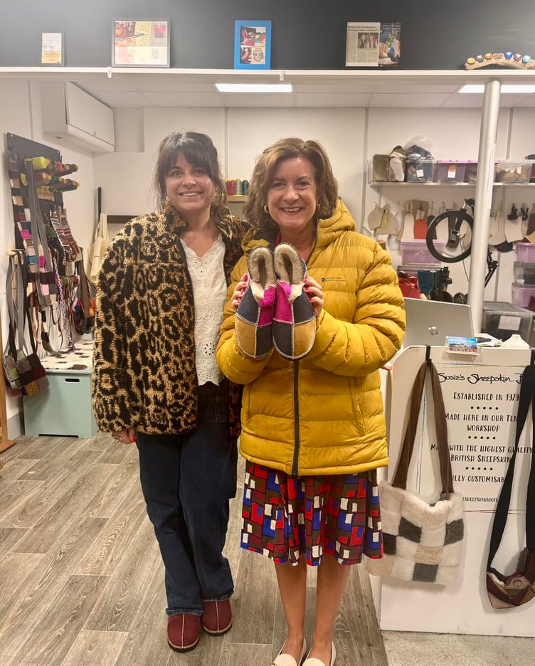 First Minister of Wales, Eluned Morgan, choosing a pair of slippers at the Susie’s Sheepskin Boots shop in Tenby’s Old Market Hall