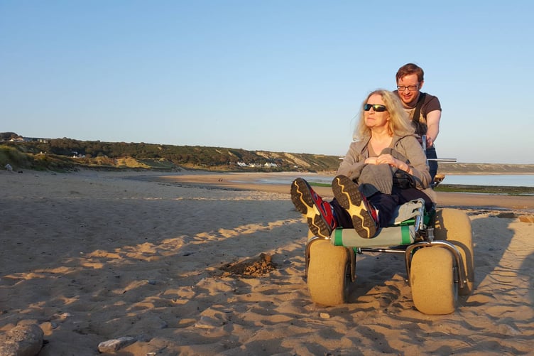 Richard Hutchinson and mum Fiona enjoying a day at the beach using one of the Park Authority’s beach wheelchairs
