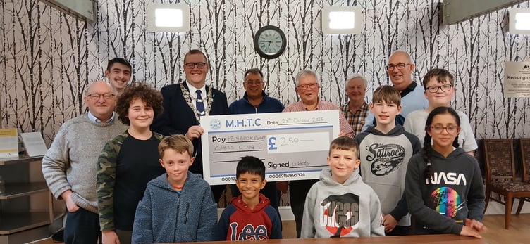Mayor of Milford Haven, Cllr William Elliott presenting the cheque alongside junior and senior members of Pembrokeshire Chess Club