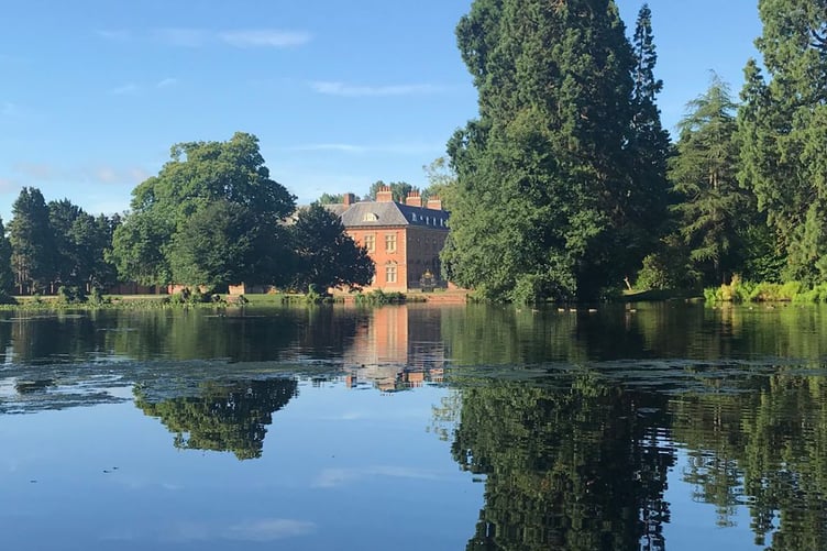 Tredegar House, Newport, Wales. Distant view of the house through the trees across the lake.