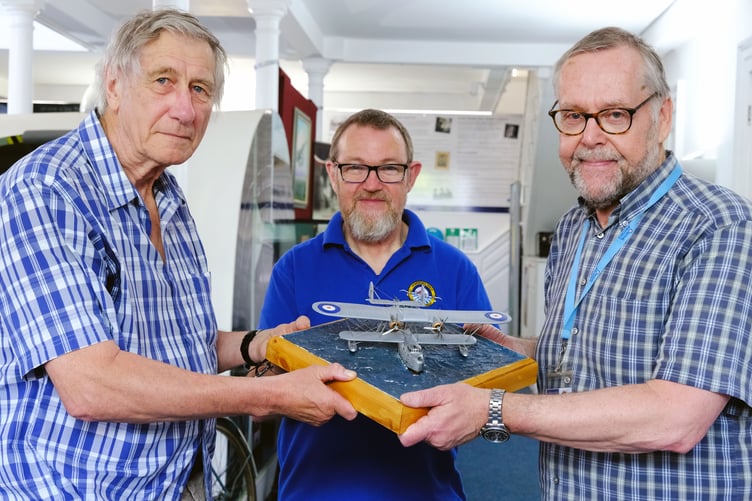 Fred Martin (left) hands over a model of a London flying boat to Paul Emens and Trevor Clark (right) of the Pembroke Dock Heritage Centre team. Photo: Martin Cavaney